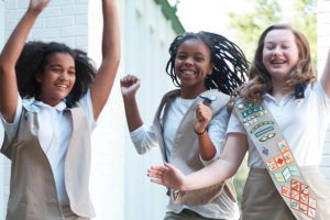 Girl Scout Ambassadors jumping with joy on their faces