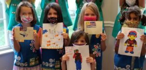 Girl Scout Daisies, Brownie, and Juniors holding letters to soldiers
