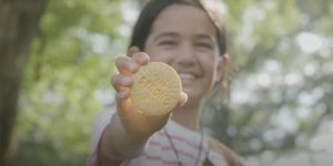 Girl holding "I Am Strong" Lemon-Up cookie